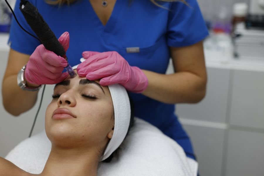 A skincare professional performing a deep cleansing facial treatment on a relaxed client using precision tools.