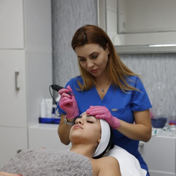 Professional skincare expert performing a Hydrafacial using advanced equipment for skin rejuvenation.
