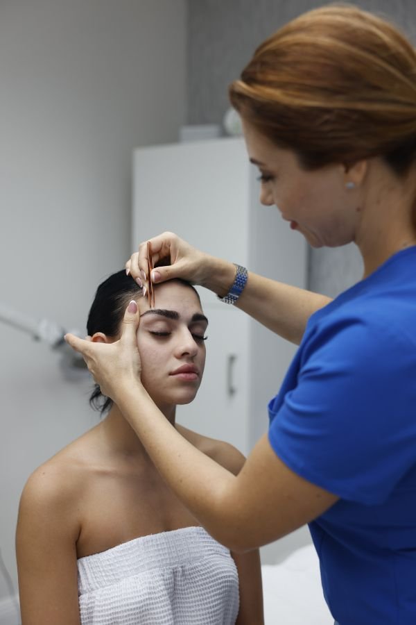 A relaxed client receiving post-treatment care after a professional skin or brow service.