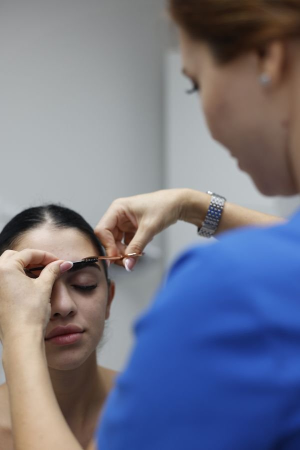 A relaxed client receiving post-treatment care after a professional skin or brow service.