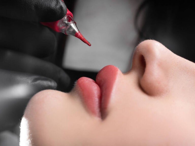 A close-up of a lip tattoo session using a precision tool to enhance the natural shape and color of the lips.