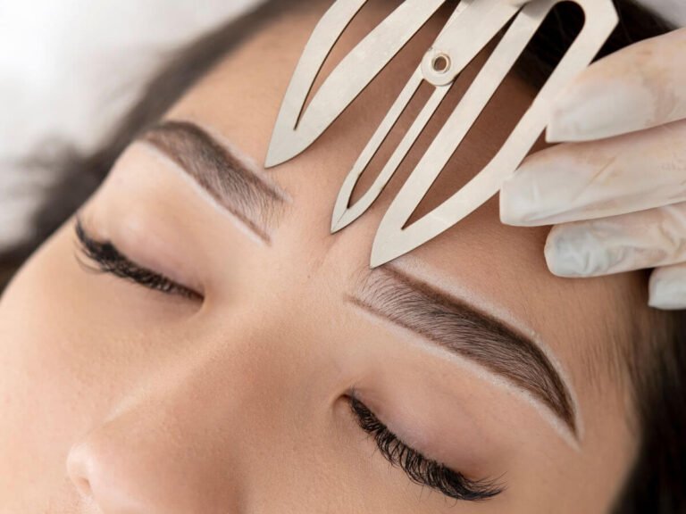 Brow mapping with fine strokes during a professional microblading session to achieve natural, hair-like results.
