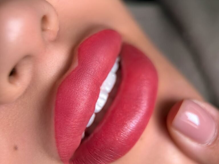 Vibrant lips receiving a precise touch-up as part of a 6-week permanent makeup follow-up session.